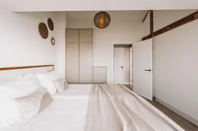 a bedroom with a large bed with white sheets at Boulevard 5 in Zandvoort