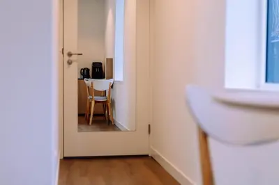a room with a table and a chair through a door at The Amsterdam Houseboat Family - de Jordaan Brand New Houseboat! in Amsterdam