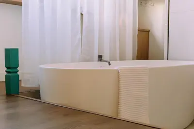 a bath tub with a faucet in a room at The Amsterdam Houseboat Family - de Jordaan Brand New Houseboat! in Amsterdam