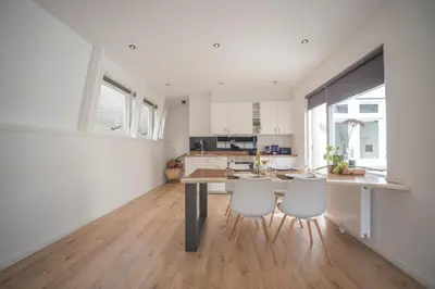 a kitchen with a table and two white chairs at Sack-Time fashion boutique hotel 1 & 2 in Zandvoort