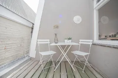 a white table and four chairs on a balcony at Sack-Time fashion boutique hotel 1 & 2 in Zandvoort