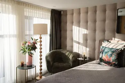 a bedroom with a bed and a chair and window at City Attic Haarlem in Haarlem