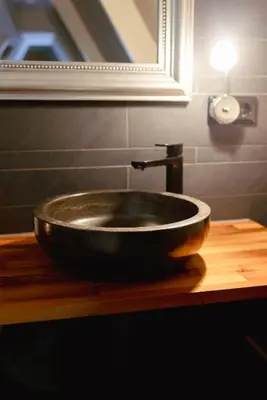 a black sink on a wooden counter in a bathroom at City Attic Haarlem in Haarlem