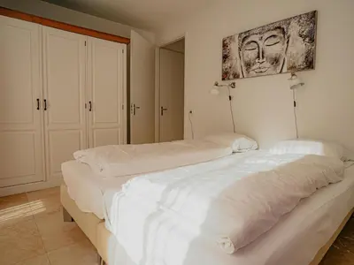 a bedroom with two beds and a painting on the wall at Apartment in Egmond aan Zee near the Beach in Egmond aan Zee