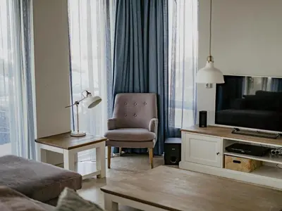 a living room with a chair and a television at Apartment in Egmond aan Zee near the Beach in Egmond aan Zee