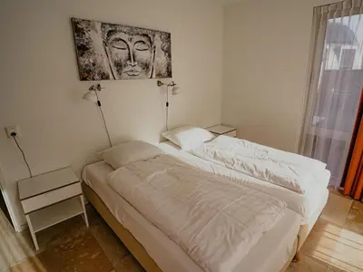 a bedroom with two beds and a picture on the wall at Apartment in Egmond aan Zee near the Beach in Egmond aan Zee