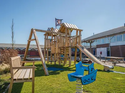 a park with a wooden playground with a slide at Apartment in Egmond aan Zee near the Beach in Egmond aan Zee