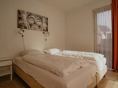 two beds in a bedroom with a picture on the wall at Apartment in Egmond aan Zee near the Beach in Egmond aan Zee