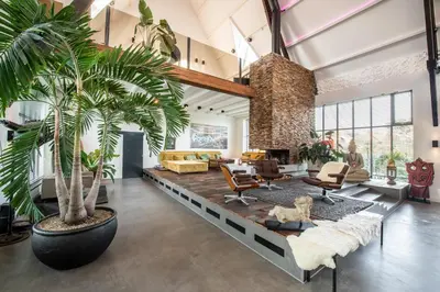 a living room with two palm trees and a couch at Het Lichthuis in Zandvoort