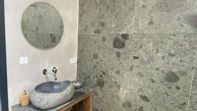 a bathroom with a stone sink and a mirror at Het Lichthuis in Zandvoort