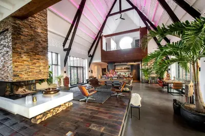 an open living room with a large brick fireplace at Het Lichthuis in Zandvoort