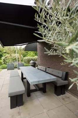 a picnic table and benches sitting next to a brick wall at Vakantiehuis Olivia in Schoorl