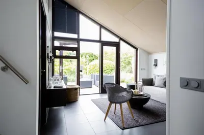 a living room with a couch and a chair at Vakantiehuis Olivia in Schoorl