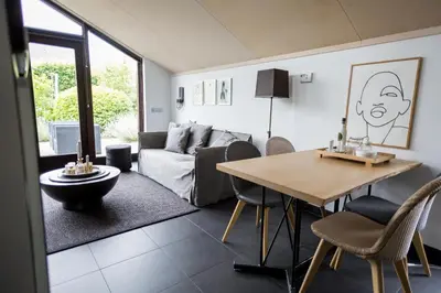 a living room with a table and a couch at Vakantiehuis Olivia in Schoorl