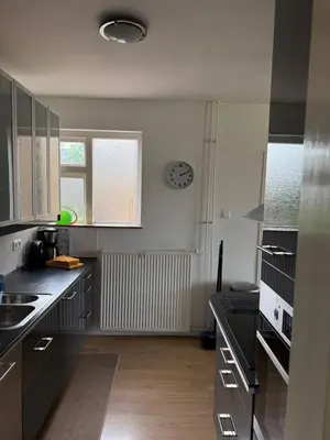 a kitchen with black counters and a clock on the wall at huize Louwra in Egmond-Binnen