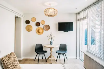 a living room with a table and chairs and a tv at West 7 in Zandvoort