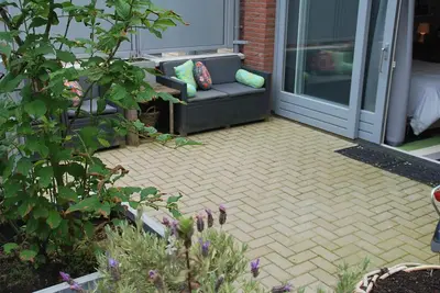 a patio with a couch in front of a door at Zandstudio in Alkmaar