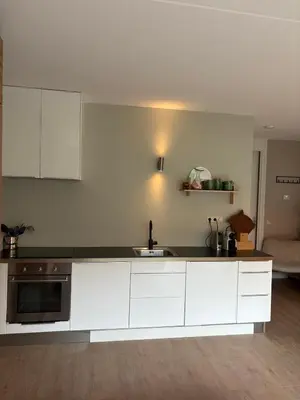 a kitchen with white cabinets and a sink at Zandstudio in Alkmaar