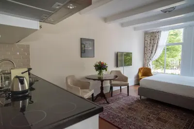 a hotel room with a bed and a kitchen and a table at Keizershouse Amsterdam in Amsterdam