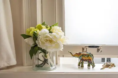 a vase of flowers on a table next to a window at Keizershouse Amsterdam in Amsterdam