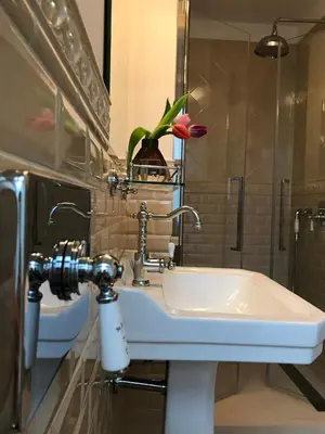 a bathroom with a sink and a vase with a flower at Keizershouse Amsterdam in Amsterdam