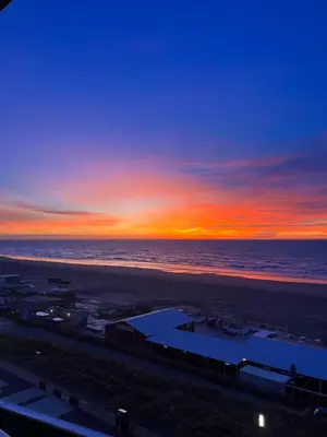 a sunset over a beach with the ocean at Apartment Marmoris in Zandvoort
