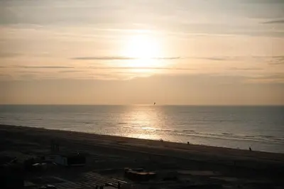 a view of the beach with the sun setting at Apartment Marmoris in Zandvoort