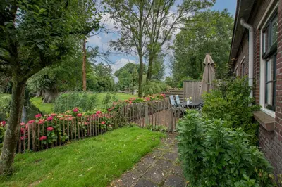 a garden with a wooden fence and flowers at Hoeve Suydeinde in Aarlanderveen
