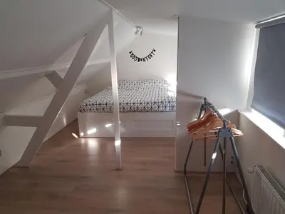 a attic room with a bed and a tripod at Vakantiehuis Katwijk Andreasplein in Katwijk