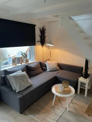 a living room with a couch and a table at Vakantiehuis Katwijk Andreasplein in Katwijk