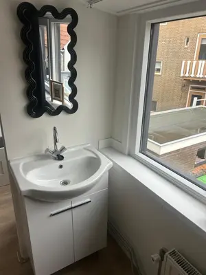 a bathroom with a sink and a window at Vakantiehuis Katwijk Andreasplein in Katwijk