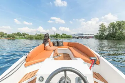 a woman sitting on the back of a boat on the water at Leonardo Hotel Vinkeveen Amsterdam in Vinkeveen