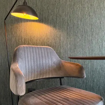 a chair sitting in a room with a lamp at B&B Mol in Katwijk aan Zee