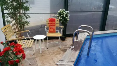 a balcony with a table and chairs next to a swimming pool at Het Findament Tiny house in Hilversum