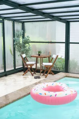 a patio with a table and chairs in a swimming pool at Het Findament Tiny house in Hilversum