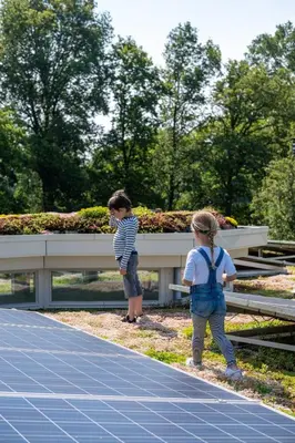 two children are standing in front of a bench at Het Findament Tiny house in Hilversum