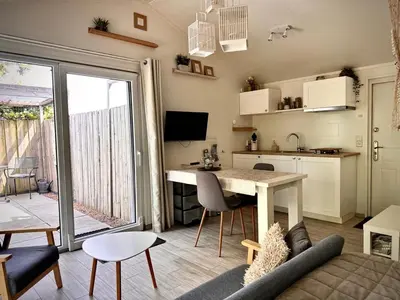 a living room with a table and a kitchen with a view at Coast Holiday Appartements in Dirkshorn