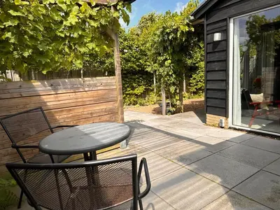 a patio with a table and chairs on a porch at Coast Holiday Appartements in Dirkshorn
