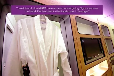 a white jacket on a hanger in an airplane at YOTELAIR Amsterdam Schiphol Transit Hotel in Schiphol