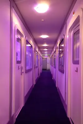 a hallway with purple walls and a long aisle at YOTELAIR Amsterdam Schiphol Transit Hotel in Schiphol