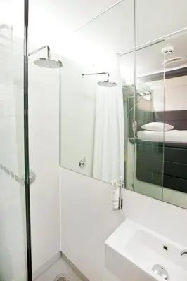 a bathroom with a sink and a mirror at YOTELAIR Amsterdam Schiphol Transit Hotel in Schiphol