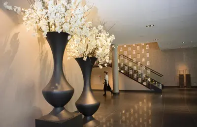 two black vases with white flowers in a hallway at Van der Valk Hotel Utrecht in Utrecht