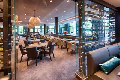 a dining room with tables and chairs and windows at Van der Valk Hotel Utrecht in Utrecht