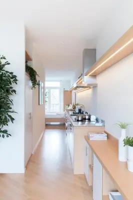 a kitchen with white walls and wooden floors at 2L Hof van Holland apartments in Noordwijk