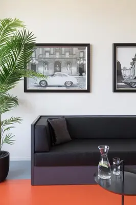 a living room with a black couch and a car at 2L Hof van Holland apartments in Noordwijk