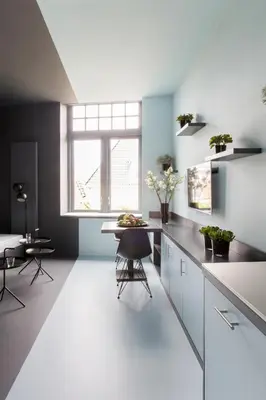 a kitchen with white counters and a table and a window at 2L Hof van Holland apartments in Noordwijk