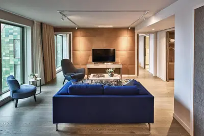 a living room with a blue couch and chairs at Hyatt Regency Amsterdam in Amsterdam