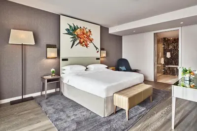 a hotel room with a large bed and a table at Hyatt Regency Amsterdam in Amsterdam