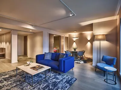 a living room with a blue couch and a table at Hyatt Regency Amsterdam in Amsterdam