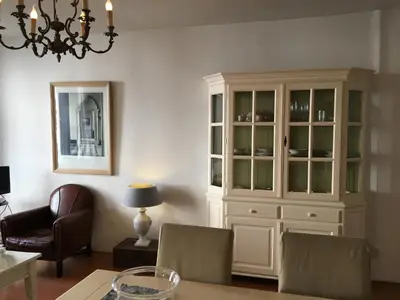 a living room with a chandelier and a white cabinet at La Perle Apartment in Utrecht